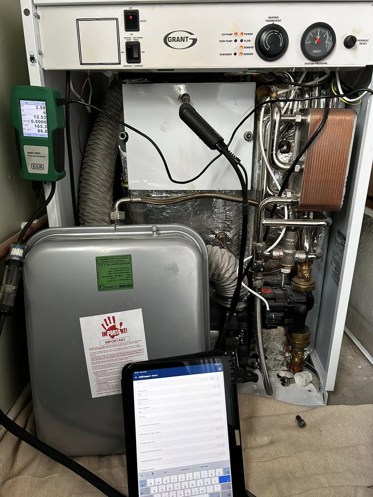 Boiler opened up beside its expansion vessel with the analyser and tablet