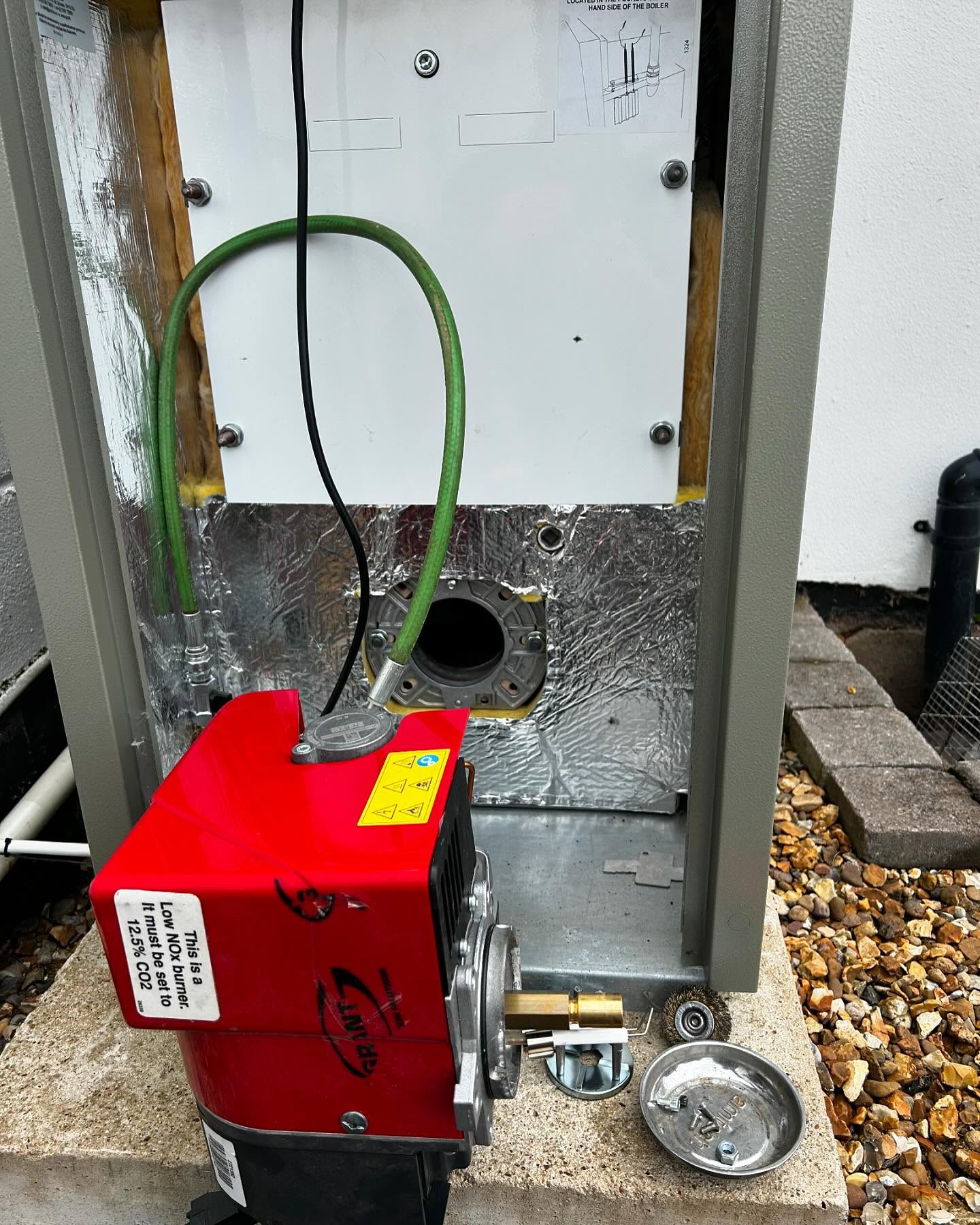 Red burner taken out of an outdoor oil boiler for servicing