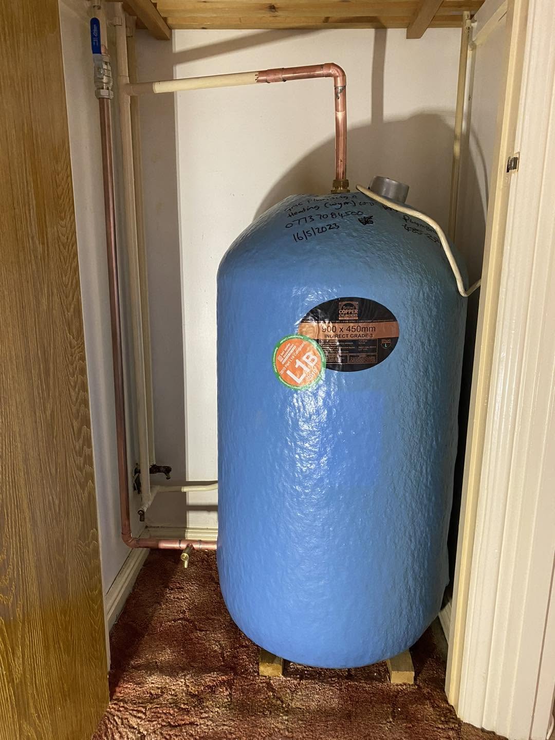 Copper hot water cylinder in an airing cupboard
