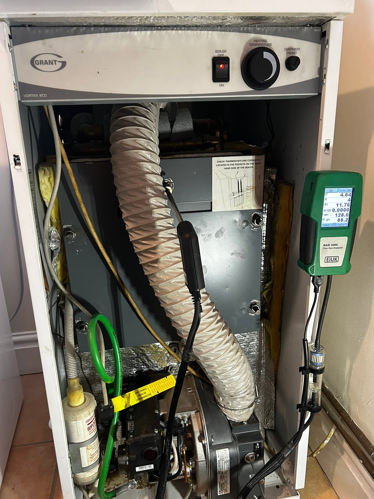 Grant oil boiler opened up with the flue hose and analyser connected