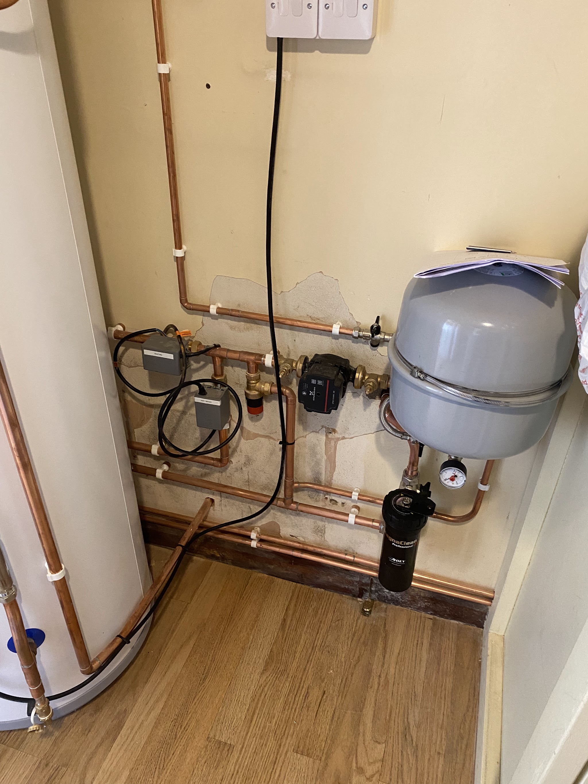 New copper pipework, pump, valves and expansion vessel in a cupboard