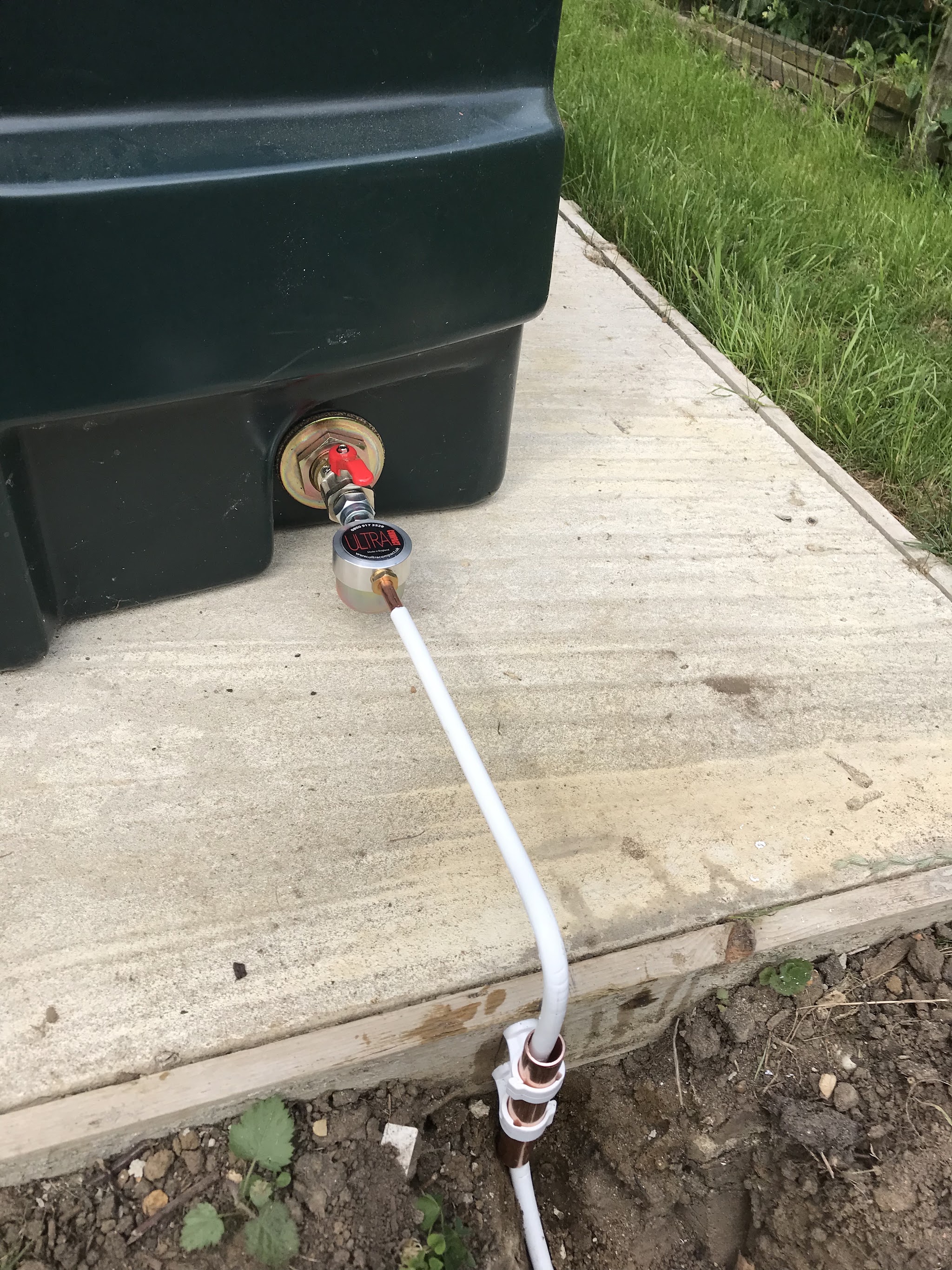 Oil tank outlet with a new supply pipe running down the concrete base