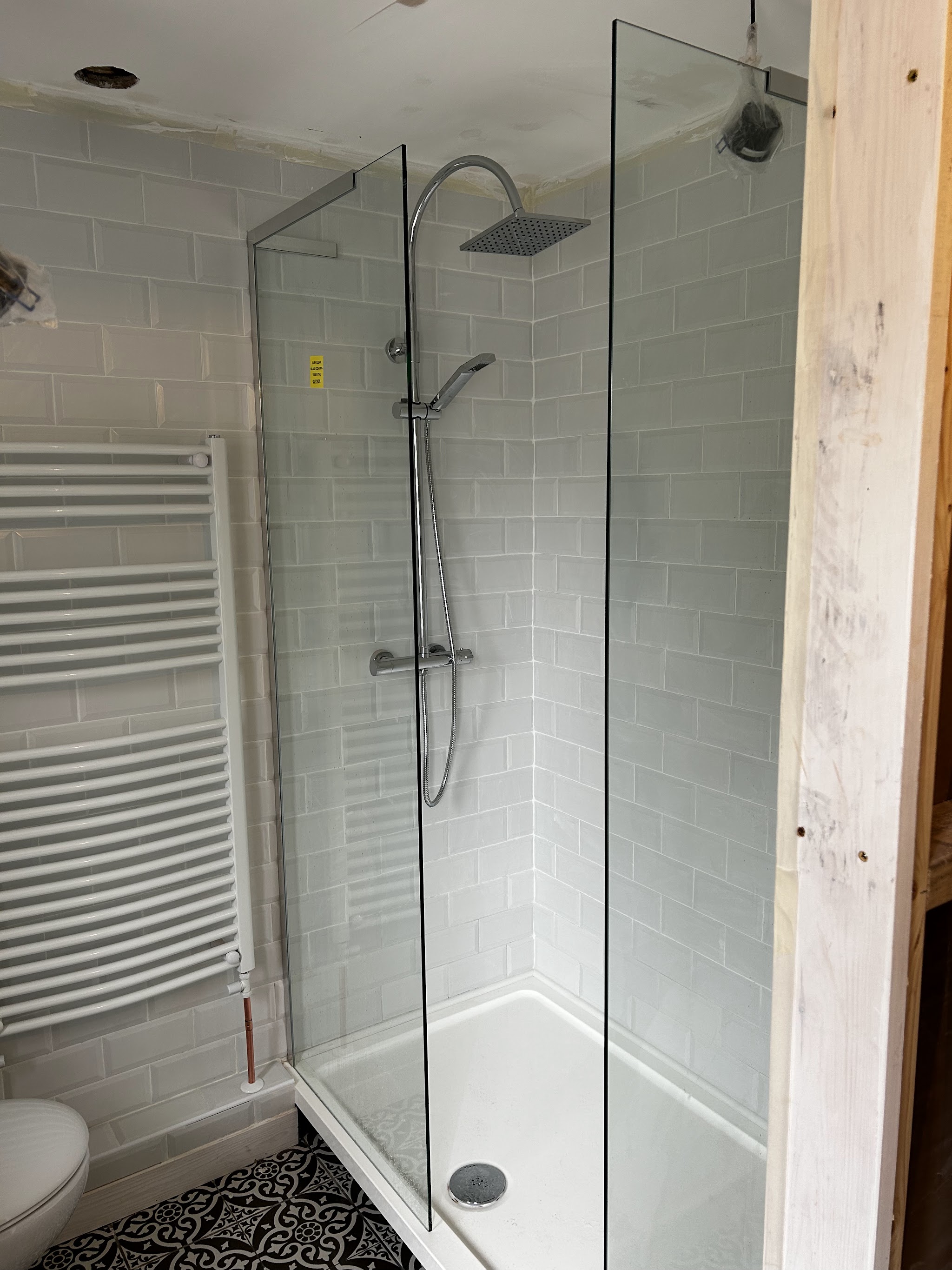 A new glass shower enclosure with a chrome shower and towel rail
